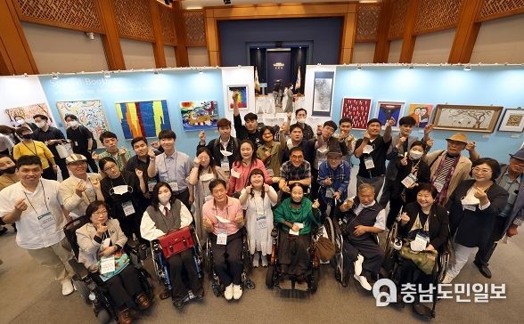 8월 31일 서울 종로구 청와대 춘추관에서 개막한 장애예술인 특별전 ‘국민 속으로 어울림 속으로’에서 발달·지체·청각 장애에도 활발히 작품 활동을 해온 참여 작가들이 손하트를 그리며 기념촬영 하고 있는 모습. (사진=문화체육관광부)